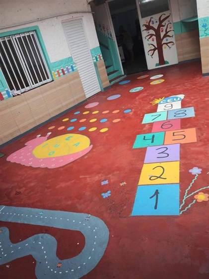 Piso do pátio pintado com amarelinha, caracol das vogais e circuito de carrinhos